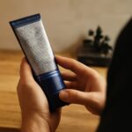 A collection of skin care products including skin numbing spray and tips for glistening male skin